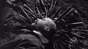 Movie still from “Dead Man” (1995), directed by Jim Jarmusch – A man laying on the ground with a bunch of bushes around him; Close Up shot, Overhead angle