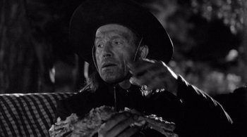Movie still from “Dead Man” (1995), directed by Jim Jarmusch – A black and white photo of a man wearing a cowboy hat; Close Up shot, Over the shoulder angle