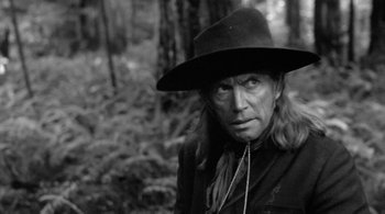 Movie still from “Dead Man” (1995), directed by Jim Jarmusch – A black and white photo of a man wearing a hat; Close Up shot, Over the shoulder angle