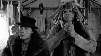Movie still from “Dead Man” (1995), directed by Jim Jarmusch – Two native american men standing next to each other; Medium shot, Over the shoulder angle