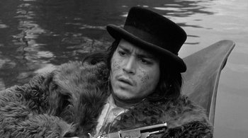 Movie still from “Dead Man” (1995), directed by Jim Jarmusch – A man in a top hat holding a gun in his hand; Close Up shot, High angle