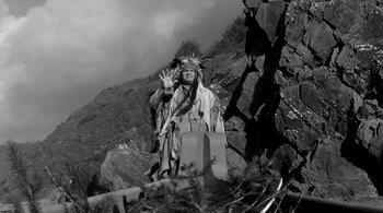 Movie still from “Dead Man” (1995), directed by Jim Jarmusch – An old photo of a man in a native american costume; Wide shot, Low angle