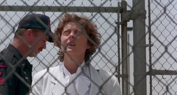 Movie still from “Dead Man Walking” (1995), directed by Tim Robbins – A woman in a white jacket standing next to a fence; Close Up shot, Low angle