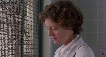 Movie still from “Dead Man Walking” (1995), directed by Tim Robbins – A woman with curly brown hair is standing in front of a metal fence; Close Up shot, Low angle