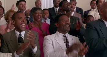 Movie still from “Dead Man Walking” (1995), directed by Tim Robbins – A group of people that are standing in a room together; Medium shot, Low angle