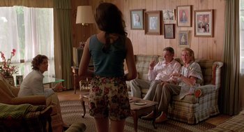 Movie still from “Dead Man Walking” (1995), directed by Tim Robbins – A woman standing in front of a group of people in a living room; Wide shot, Over the shoulder angle