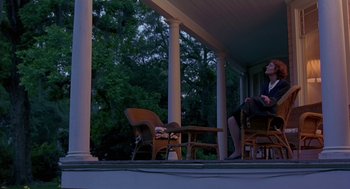 Movie still from “Dead Man Walking” (1995), directed by Tim Robbins – Two people sitting on chairs on a porch at night; Wide shot, Low angle
