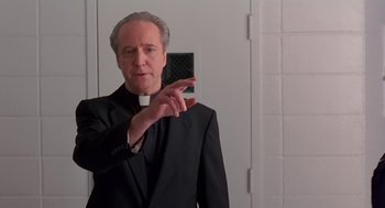 Movie still from “Dead Man Walking” (1995), directed by Tim Robbins – A man in a black suit holding up a cell phone; Medium shot, Low angle