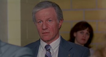 Movie still from “Dead Man Walking” (1995), directed by Tim Robbins – An older man wearing a suit and tie; Close Up shot, Low angle