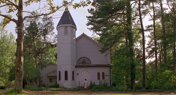 Movie still from “Dead Man Walking” (1995), directed by Tim Robbins – A man standing in front of a church in the woods; Extreme Wide shot, Low angle