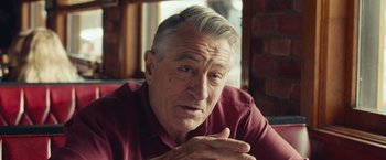 Movie still from “Dirty Grandpa” (2016), directed by Dan Mazer – An older man sitting in front of a brick wall; Close Up shot, Over the shoulder angle