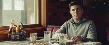 Movie still from “Dirty Grandpa” (2016), directed by Dan Mazer – A man sitting at a table in front of a plate of food; Medium shot, Over the shoulder angle