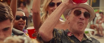Movie still from “Dirty Grandpa” (2016), directed by Dan Mazer – An older man and a young woman at an outdoor event; Close Up shot, Low angle