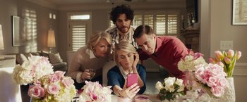 Movie still from “Dirty Grandpa” (2016), directed by Dan Mazer – A group of people sitting around a dining room table taking a selfie; Medium shot, High angle