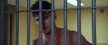 Movie still from “Dirty Grandpa” (2016), directed by Dan Mazer – A shirtless man standing behind a metal fence; Close Up shot, Low angle