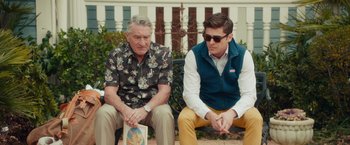 Movie still from “Dirty Grandpa” (2016), directed by Dan Mazer – Two men sitting on a park bench , one holding a book; Medium shot, Over the shoulder angle
