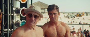Movie still from “Dirty Grandpa” (2016), directed by Dan Mazer – A man and an older man posing for a picture; Medium shot, Over the shoulder angle