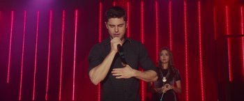 Movie still from “Dirty Grandpa” (2016), directed by Dan Mazer – A man holding a microphone in front of a woman; Medium shot, Low angle