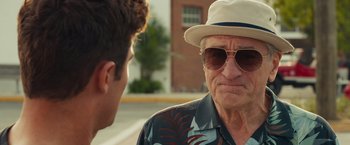 Movie still from “Dirty Grandpa” (2016), directed by Dan Mazer – An older man wearing sunglasses and a hat talking to a younger man; Close Up shot, Over the shoulder angle