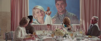 Movie still from “Dirty Grandpa” (2016), directed by Dan Mazer – A woman standing in front of a picture of a man and a woman; Wide shot, Over the shoulder angle