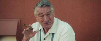 Movie still from “Dirty Grandpa” (2016), directed by Dan Mazer – An older man smoking a cigarette while holding a cigar in his hand; Close Up shot, Over the shoulder angle