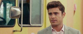 Movie still from “Dirty Grandpa” (2016), directed by Dan Mazer – A man wearing a suit and tie standing next to a bus; Close Up shot, Over the shoulder angle