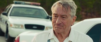 Movie still from “Dirty Grandpa” (2016), directed by Dan Mazer – An older man standing in front of a cop car; Close Up shot, Over the shoulder angle