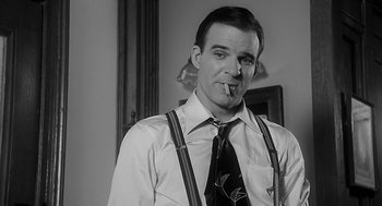 Movie still from “Dead Men Don't Wear Plaid” (1982), directed by Carl Reiner – A black and white photo of a man smoking a cigarette; Close Up shot, Low angle