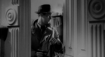 Movie still from “Dead Men Don't Wear Plaid” (1982), directed by Carl Reiner – A black and white photo of a man in a hat; Medium shot, Over the shoulder angle