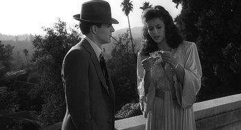 Movie still from “Dead Men Don't Wear Plaid” (1982), directed by Carl Reiner – A man and a woman standing next to each other; Medium shot, Over the shoulder angle