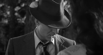 Movie still from “Dead Men Don't Wear Plaid” (1982), directed by Carl Reiner – A black and white photo of a man in a suit and hat; Close Up shot, High angle