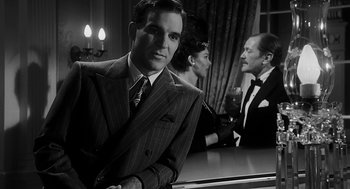 Movie still from “Dead Men Don't Wear Plaid” (1982), directed by Carl Reiner – A black and white photo of a man in a suit and tie; Medium shot, Over the shoulder angle