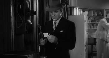 Movie still from “Dead Men Don't Wear Plaid” (1982), directed by Carl Reiner – A black and white photo of a man in a suit and hat; Close Up shot, Low angle