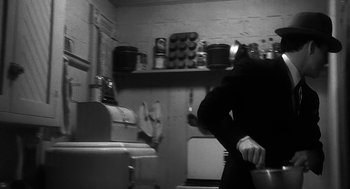 A person in a kitchen holding a knife