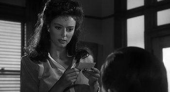 Movie still from “Dead Men Don't Wear Plaid” (1982), directed by Carl Reiner – A woman holding a piece of paper in front of a window; Close Up shot, Over the shoulder angle