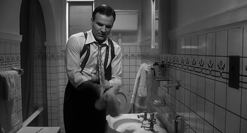 Movie still from “Dead Men Don't Wear Plaid” (1982), directed by Carl Reiner – A black and white photo of a man washing his hands in a bathroom; Medium shot, Low angle