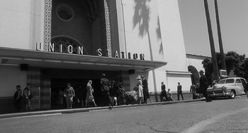 Movie still from “Dead Men Don't Wear Plaid” (1982), directed by Carl Reiner – A black and white photo of people walking on the sidewalk; Extreme Wide shot, Low angle