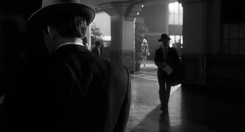 Movie still from “Dead Men Don't Wear Plaid” (1982), directed by Carl Reiner – A black and white photo of a man in a suit and a hat; Medium shot, Over the shoulder angle