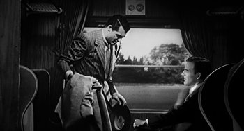 Movie still from “Dead Men Don't Wear Plaid” (1982), directed by Carl Reiner – A black and white photo of a man on a train; Medium shot, Over the shoulder angle