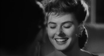 Movie still from “Dead Men Don't Wear Plaid” (1982), directed by Carl Reiner – A black - and - white photo of a woman smiling for the camera; Close Up shot, Over the shoulder angle