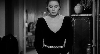 Movie still from “Dead Men Don't Wear Plaid” (1982), directed by Carl Reiner – A black and white photo of a woman in a black dress; Medium shot, Over the shoulder angle