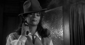 Movie still from “Dead Men Don't Wear Plaid” (1982), directed by Carl Reiner – A woman holding a gun while wearing a hat; Close Up shot, Low angle