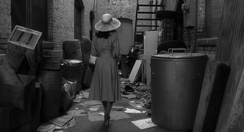 Movie still from “Dead Men Don't Wear Plaid” (1982), directed by Carl Reiner – A woman in a hat walking down a street; Wide shot, High angle