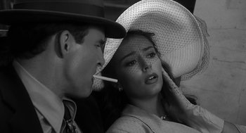 Movie still from “Dead Men Don't Wear Plaid” (1982), directed by Carl Reiner – A man and a woman are smoking a cigarette together; Close Up shot, High angle