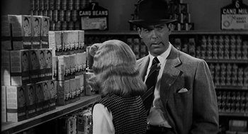 Movie still from “Dead Men Don't Wear Plaid” (1982), directed by Carl Reiner – A man and a woman talking in a store; Medium shot, Over the shoulder angle