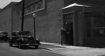 Movie still from “Dead Men Don't Wear Plaid” (1982), directed by Carl Reiner – A black and white photo of people standing in front of a building; Extreme Wide shot, Low angle