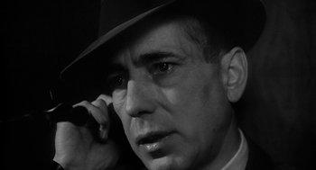Movie still from “Dead Men Don't Wear Plaid” (1982), directed by Carl Reiner – A black and white photo of a man talking on a cell phone; Close Up shot, Low angle