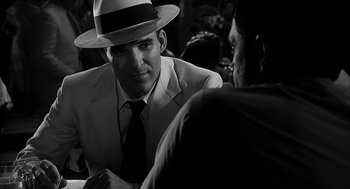 Movie still from “Dead Men Don't Wear Plaid” (1982), directed by Carl Reiner – A black and white photo of a man in a suit and a hat; Close Up shot, Over the shoulder angle