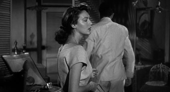 Movie still from “Dead Men Don't Wear Plaid” (1982), directed by Carl Reiner – An old photo of a woman and a man standing back to back; Close Up shot, Over the shoulder angle