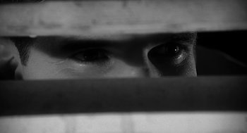 A man looking through a window at something